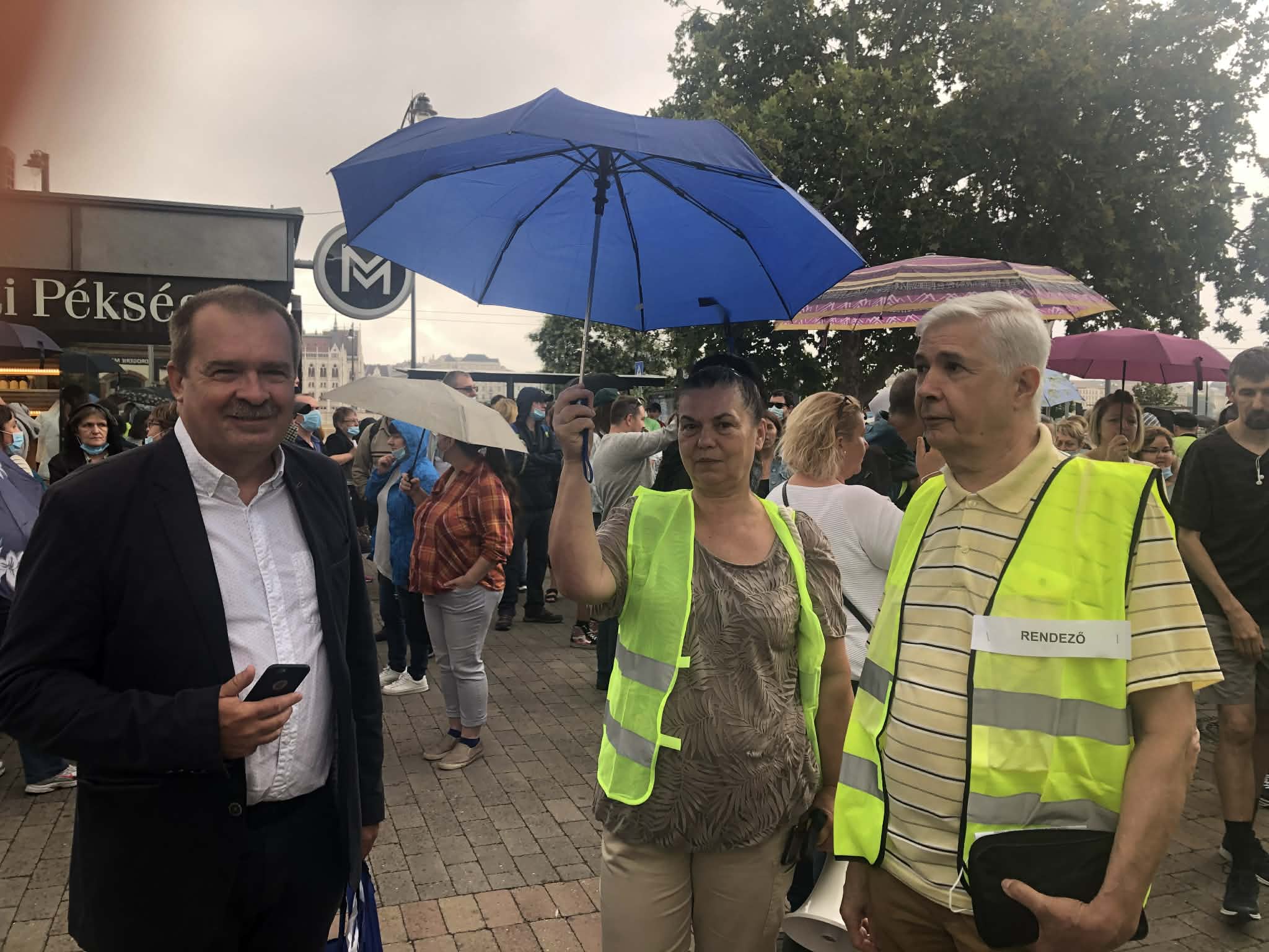 A demonstráció résztvevői táblákkal és szakszervezeti zászlókkal állnak ki a postai dolgozók magasabb bérezéséért.