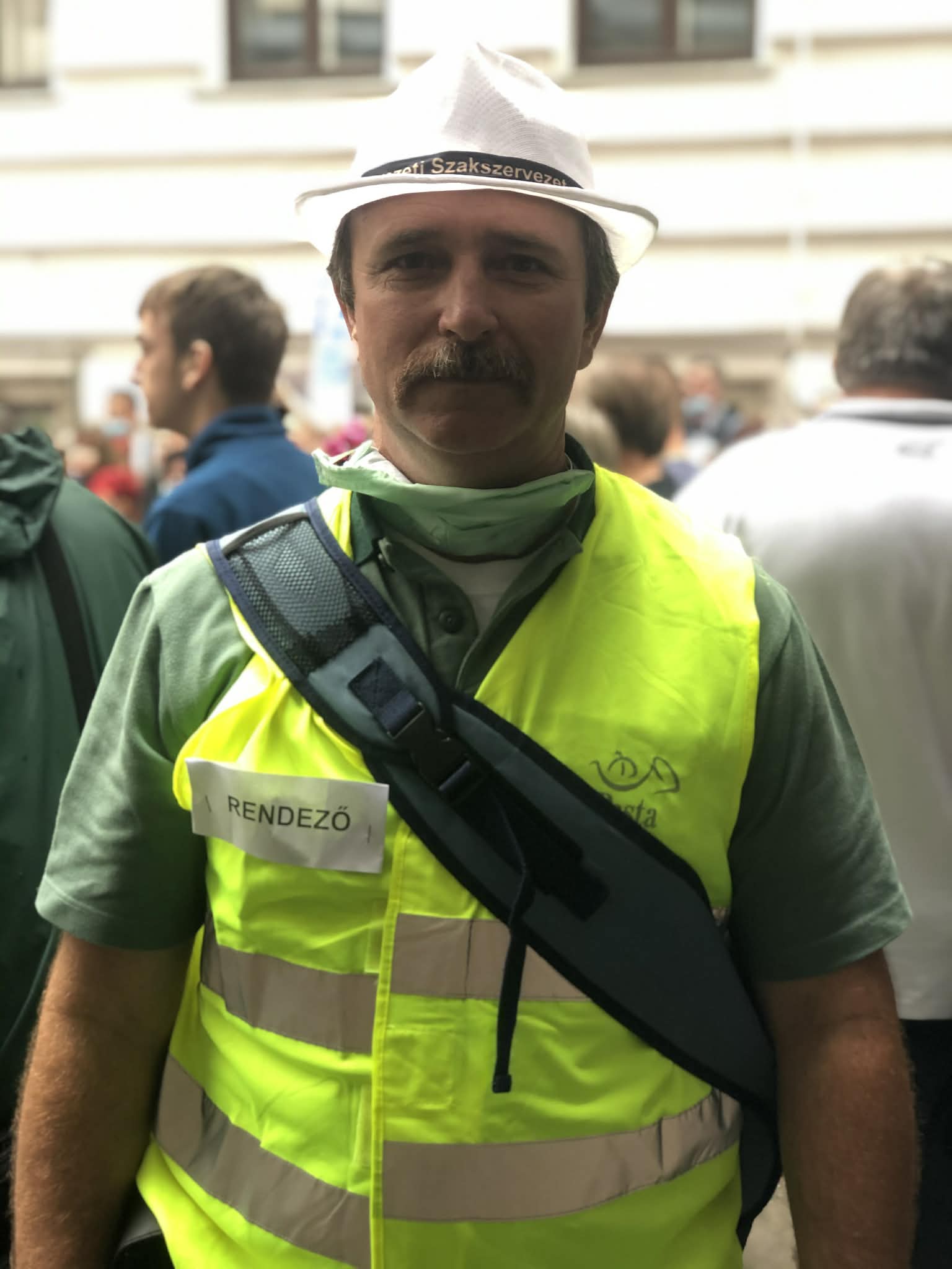A postások béremeléséért szervezett demonstráció egyik résztvevője láthatósági mellényben a vonulás során.