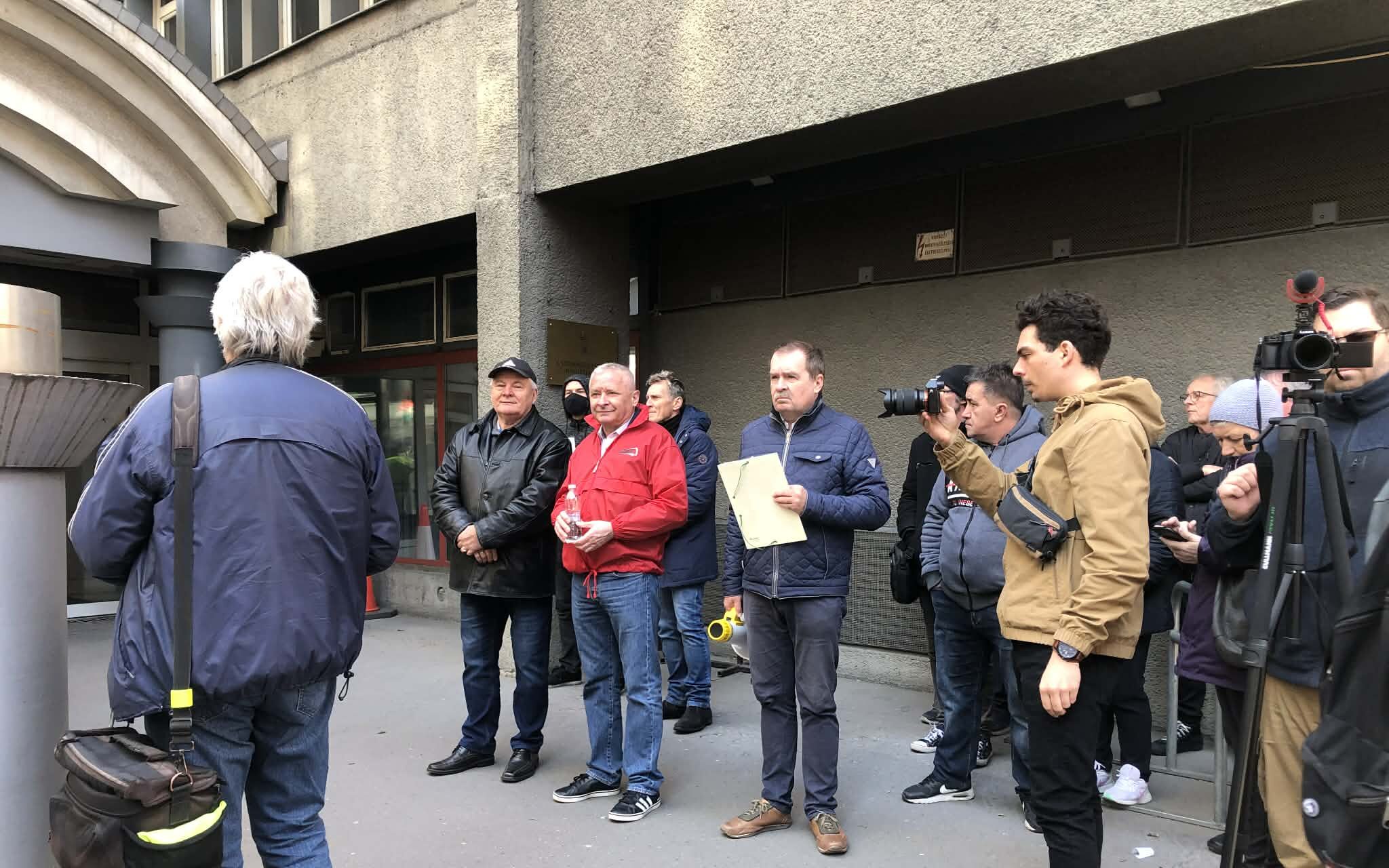 A postai dolgozók béremeléséért szervezett demonstráció résztvevői petíciót adnak át a Gazdaságfejlesztési Minisztérium bejáratánál.